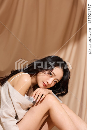 以米色織物為背景拍攝的年輕女子的奢華美麗肖像 127921787