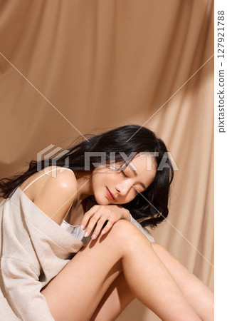 以米色織物為背景拍攝的年輕女子的奢華美麗肖像 127921788