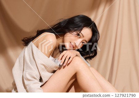 以米色織物為背景拍攝的年輕女子的奢華美麗肖像 以米色織物為背景拍攝的年輕女子的奢華美麗肖像 127921790
