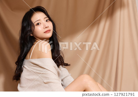 以米色織物為背景拍攝的年輕女子的奢華美麗肖像 以米色織物為背景拍攝的年輕女子的奢華美麗肖像 127921791