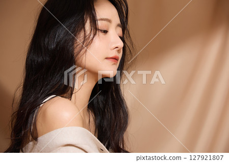 以米色織物為背景拍攝的年輕女子的奢華美麗肖像 以米色織物為背景拍攝的年輕女子的奢華美麗肖像 127921807