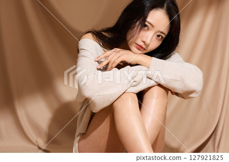 以米色織物為背景拍攝的年輕女子的奢華美麗肖像 以米色織物為背景拍攝的年輕女子的奢華美麗肖像 127921825
