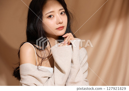 Luxurious beauty portrait of a young woman photographed against a beige fabric background 127921829