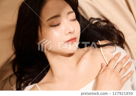 Luxurious beauty portrait of a young woman photographed against a beige fabric background 127921850