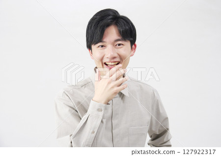 20 多歲的男子，驚訝地微笑，白色背景 127922317