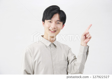 20 多歲的男子指著右邊，白色背景 127922327