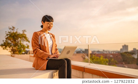 Woman working on a laptop on the roof Woman working on a laptop on the roof 127922832