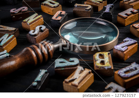 Vintage Letters and Magnifying Glass on Black Wooden Background for Research or Analysis Concept Vintage Letters and Magnifying Glass on Black Wooden Background for Research or Analysis Concept 127923157