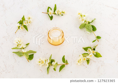 Body care products and branches of jasmine on the white background. 127923365