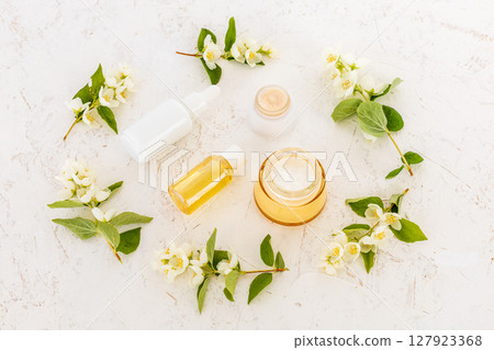 Body care products and branches of jasmine on the white background. Body care products and branches of jasmine on the white background. 127923368