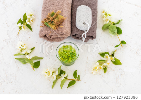 Towels with body care products and branches of jasmine on the white background. Towels with body care products and branches of jasmine on the white background. 127923386