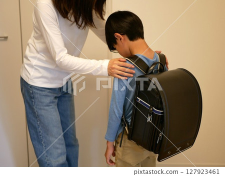 A mother encouraging a child who is looking down 127923461