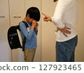 Boy crying after being scolded by his mother 127923465