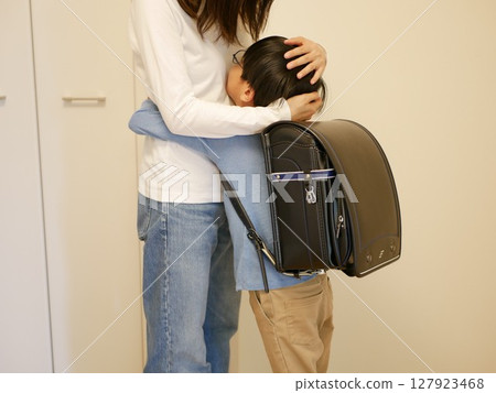 Elementary school boy hugging his mother Elementary school boy hugging his mother 127923468