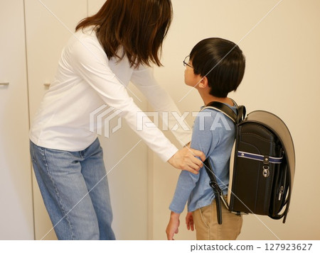 A mother holds her child's arm and tells him something important 127923627