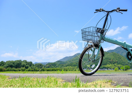 Rural nature cycle path and bicycles on blue sky background Rural nature cycle path and bicycles on blue sky background 127923751