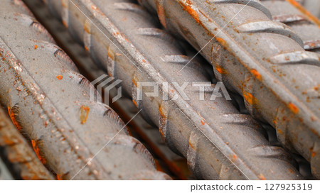 Steel reinforcement for concrete reinforcement. Pile of steel rebars stacked on a construction site 127925319