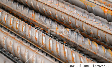Steel reinforcement for concrete reinforcement. Pile of steel rebars stacked on a construction site 127925320