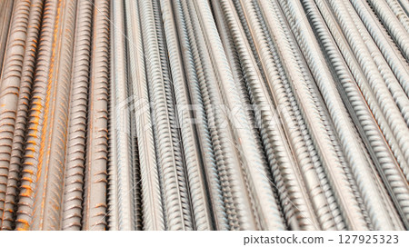 Steel reinforcement for concrete reinforcement. Pile of steel rebars stacked on a construction site 127925323