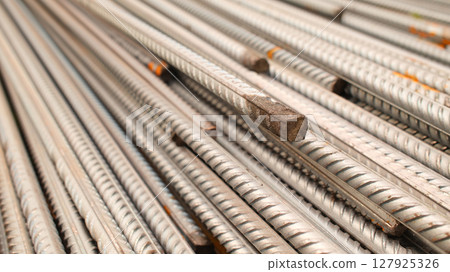 Steel reinforcement for concrete reinforcement. Pile of steel rebars stacked on a construction site 127925326