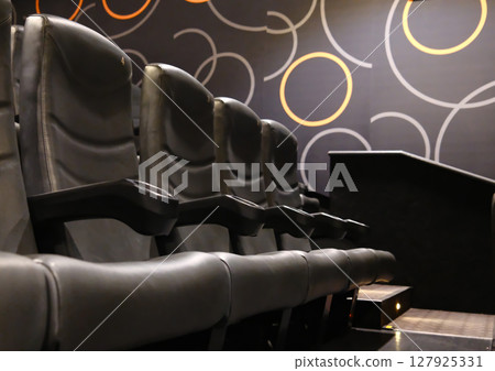 Rows of empty black leather cinema seats with cup holders Rows of empty black leather cinema seats with cup holders 127925331