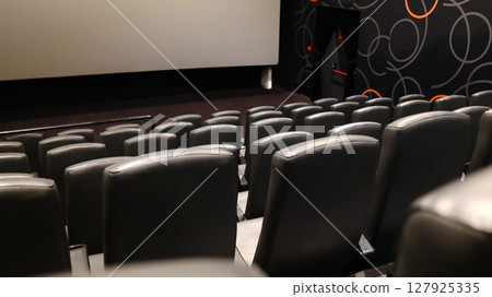 Rows of empty black leather cinema seats in a modern movie theater Rows of empty black leather cinema seats in a modern movie theater 127925335