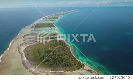 Stunning beauty of Tikehau atoll motu tropical island from above, aerial view vibrant lagoon, lush vegetation, deep blue ocean in French Polynesia. Remote wild nature paradise exotic travel background 127925640