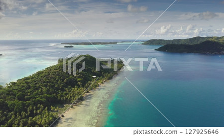 Stunning aerial drone footage captures the beauty of Bora Bora's lagoon, showcasing crystal-clear turquoise waters, vibrant coral reefs, and lush tropical islands under a cloudy sky Stunning aerial drone footage captures the beauty of Bora Bora's lagoon, showcasing crystal-clear turquoise waters, vibrant coral reefs, and lush tropical islands under a cloudy sky 127925646