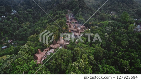 Aerial view capturing a traditional village with typical houses nestled among the lush tropical vegetation of Sumba island, Indonesia, showcasing cultural heritage and natural beauty 127925684