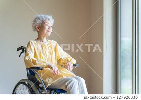 一位坐在輪椅上放鬆的老年婦女 一位坐在輪椅上放鬆的老年婦女 127926330