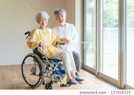 一位老人照顧一位坐輪椅的老年婦女 127926335
