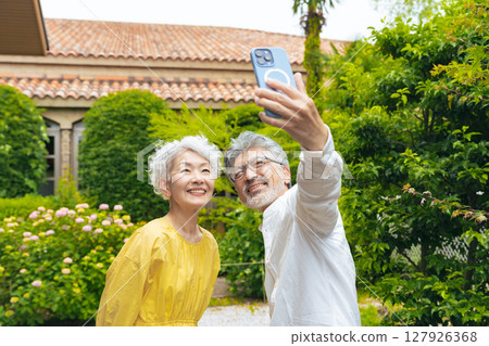 Senior couple taking a selfie with a smartphone in the garden 127926368
