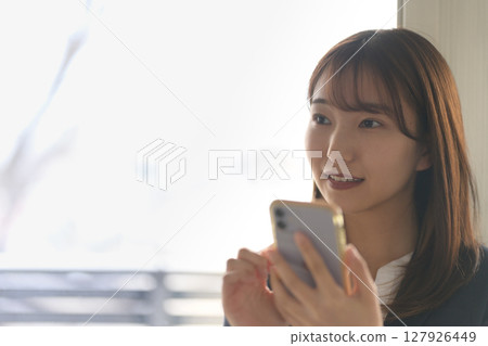 Woman operating a smartphone 127926449