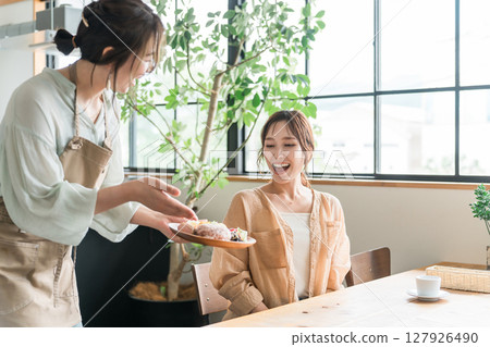 一名店員和一名女顧客在咖啡館提供一盤午餐 127926490