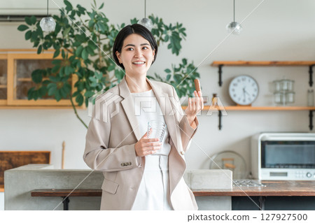 身穿西裝的亞洲年輕女性正在吃營養補充品、蛋白棒、營養棒當早餐或零食 127927500