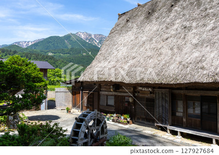 A traditional thatched roof house surrounded by blue skies and green mountains in Shirakawa-go in early summer A traditional thatched roof house surrounded by blue skies and green mountains in Shirakawa-go in early summer 127927684