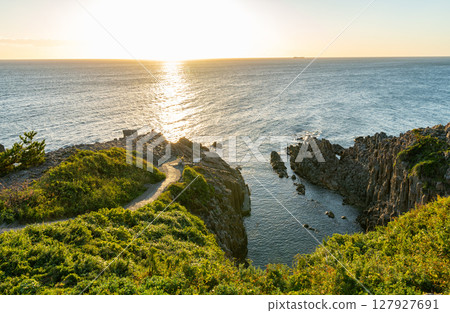 Sakai City, Fukui Prefecture: A popular tourist spot, Tojinbo at dusk, with the sun setting beautifully on the horizon 127927691