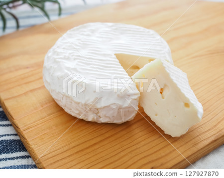 Sliced camembert cheese on a cutting board 127927870