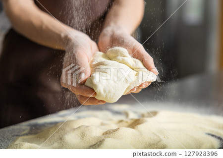 Person kneads dough kitchen pressing firmly preparing pizza base Person kneads dough kitchen pressing firmly preparing pizza base 127928396