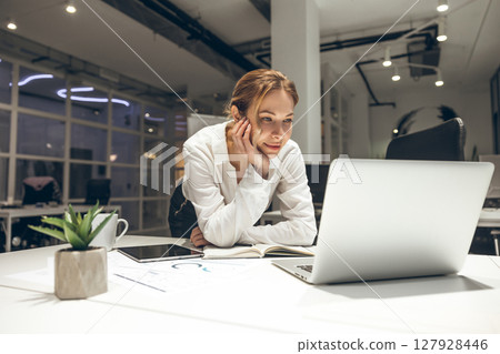 Businesswoman managing projects on laptop in stylish office setup Businesswoman managing projects on laptop in stylish office setup 127928446