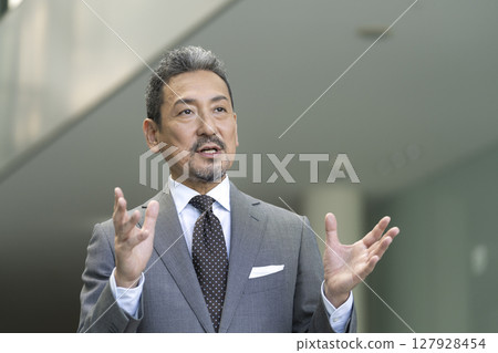 一位穿著西裝的老人用手勢說話 127928454