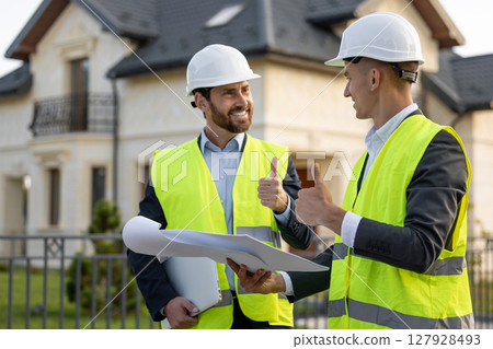 Construction workers reviewing plans in residential area 127928493