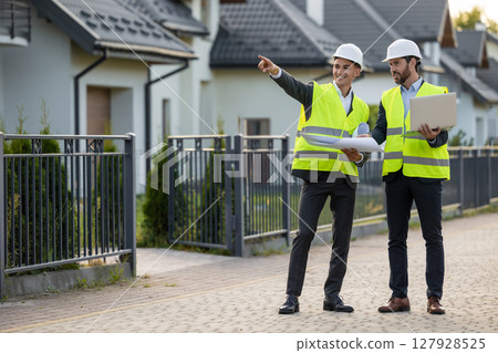 Engineers discussing project with digital tools 127928525