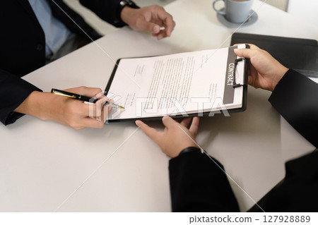 Professional agreement being signed, symbolizing partnership, commitment, or closing a deal. Professional agreement being signed, symbolizing partnership, commitment, or closing a deal. 127928889