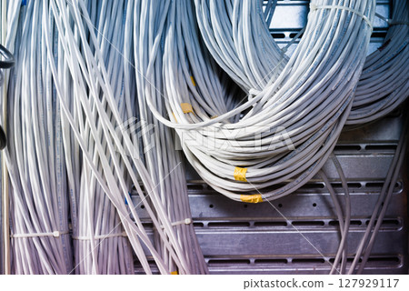 bunch of network cables in wave pattern leading across server ro bunch of network cables in wave pattern leading across server ro 127929117