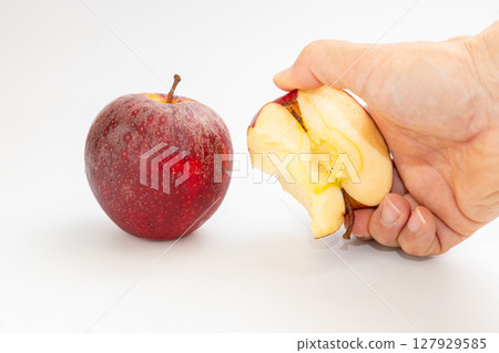 一名男子手持紐西蘭小蘋果和切好的蘋果的庫存照片 127929585