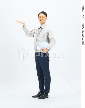 Full-body photo of a middle-aged man wearing work clothes giving directions Full-body photo of a middle-aged man wearing work clothes giving directions 127929826