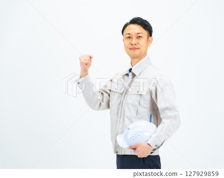 A middle-aged man in work clothes making a fist pump 127929859