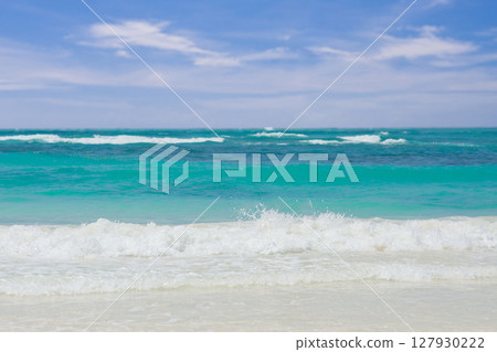 Explore a Serene and Beautiful Tropical Beach Featuring Gentle Waves and Pristine Clear Blue Water 127930222