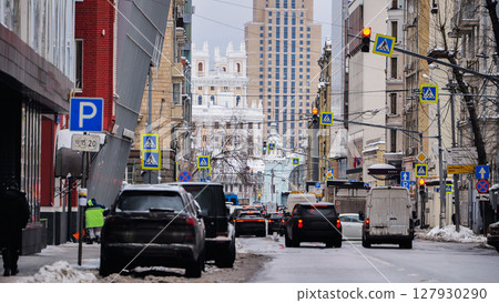 Cars driving on snowy street in Moscow city center 127930290